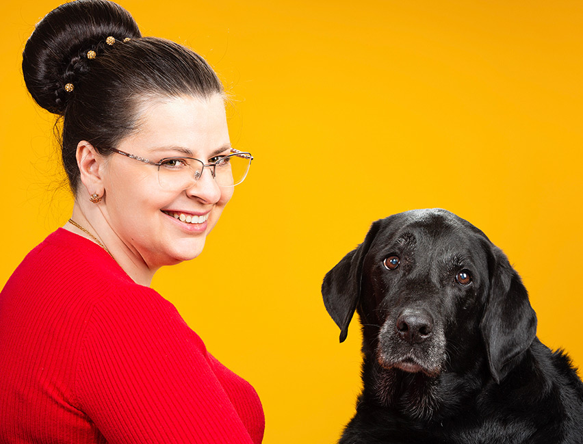 Elena ja avustajakoira Gunnar, musta labrador