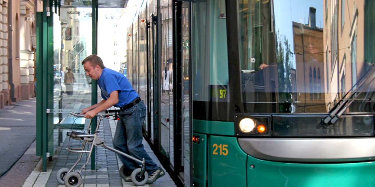 Mies poistuu raitiovaunusta rollaatorilla