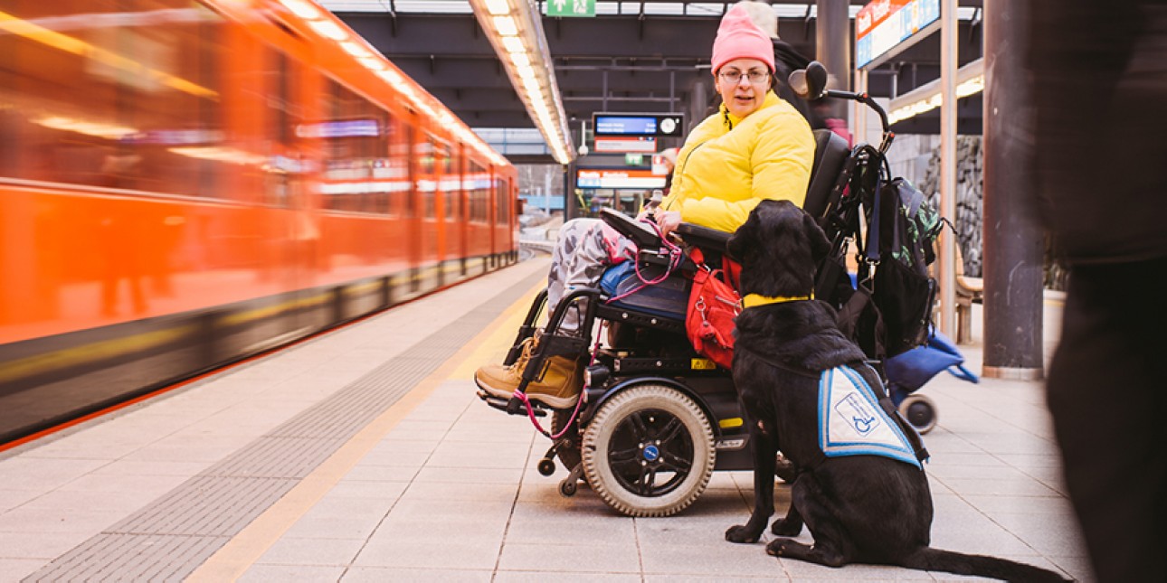Avustajakoira ja koiran käyttäjä metroasemalla