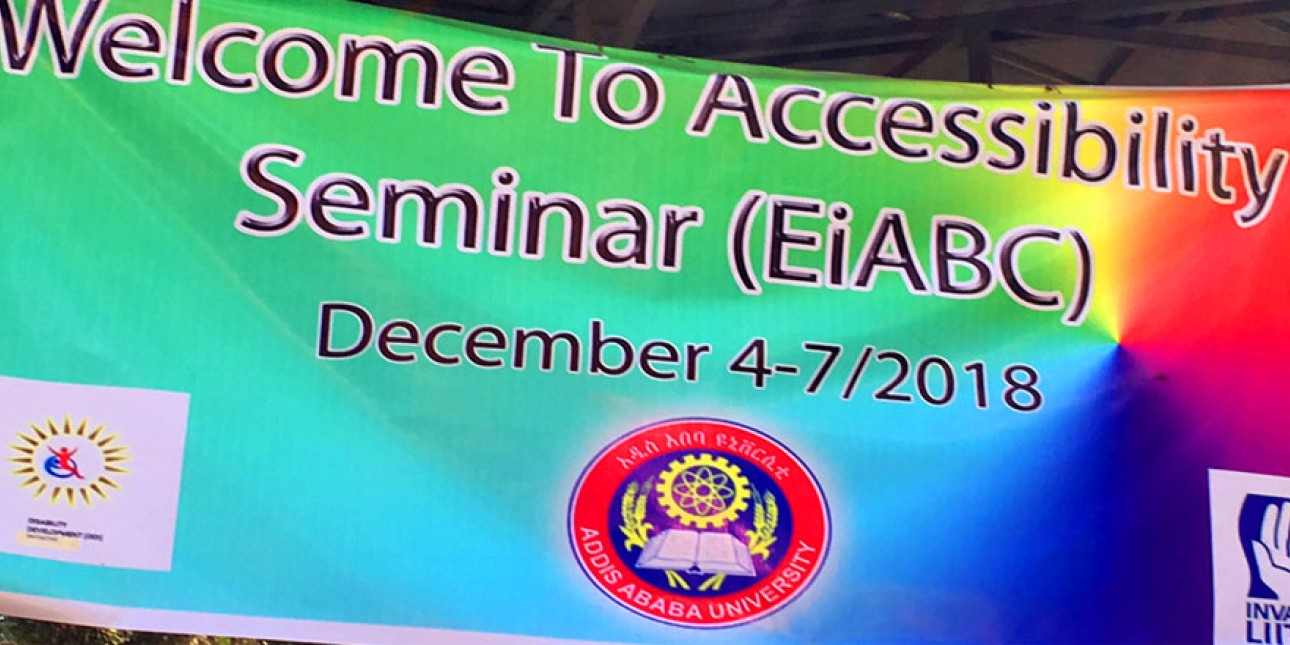 Banderollissa teksti Welcome To Accessibility Seminar (EiABC) December 4-7/2018. Alla mm. Invalidiliiton logo. Banderollin värinä vihreää, sinistä, keltaista, punaista.