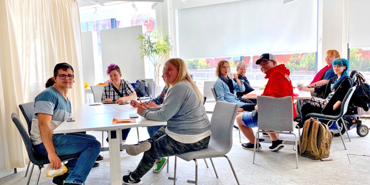 ryhmä nuoria pöytien ääressä
