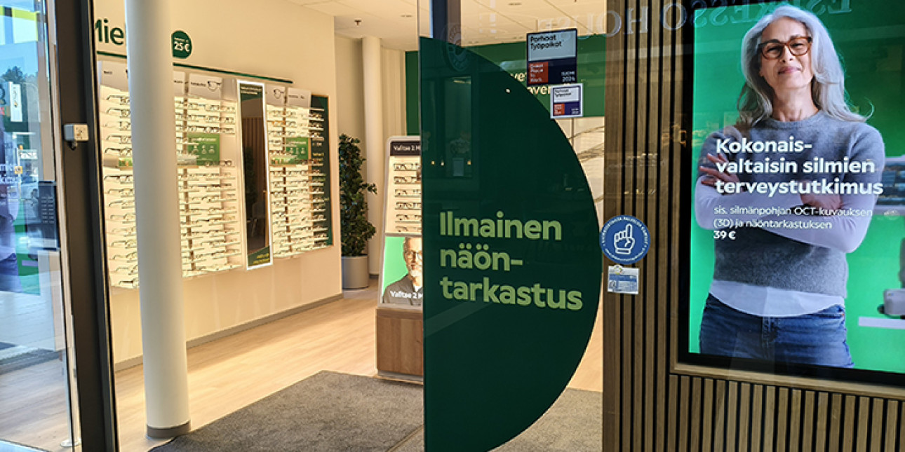Optikkoliikkeen sisäänkäynti, ovessa liikkeen mainos ja YPK-merkki