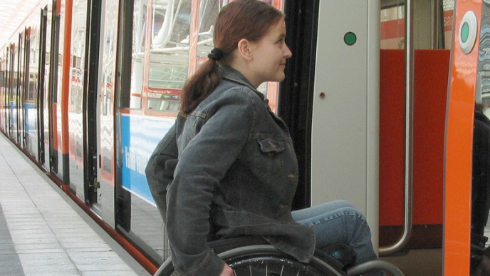 nuori nainen menossa metroon pyörätuolissa