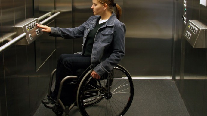Pyörätuolia käyttävä henkilö hississä.