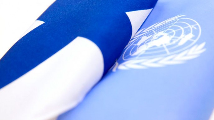 kuvassa Suomen lippu ja YK:n lippu vierekkäin