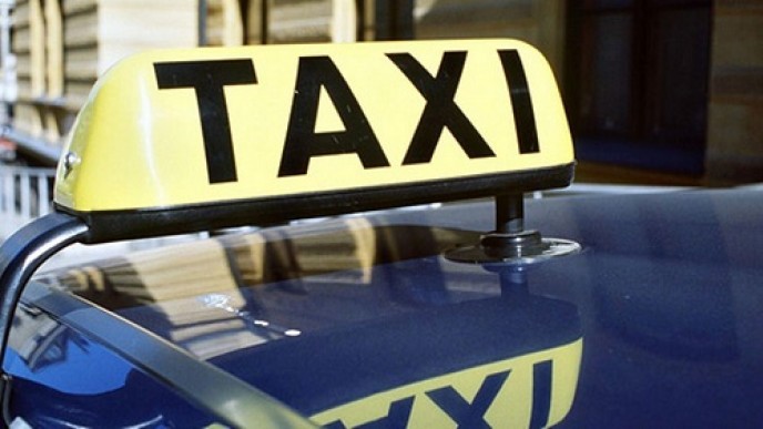 Taxi-kyltti taksn katolla keltaisella pohjalla
