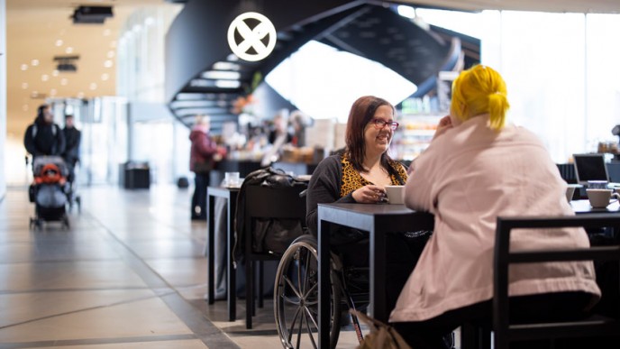 Oodi-kirjaston kahvilassa istuu asiakkaita keskustelemassa.
