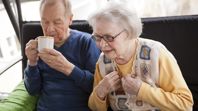 Seniori-ikäiset nainen ja mies kahvilla.