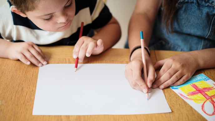 Lapsi katsoo kun aikuinen piirtää tyhjälle paperille. Kuvituskuva.