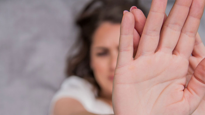 Kuvassa nainen torjuvana käsi edessä