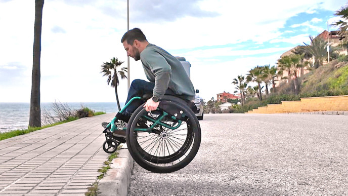 Henry Manni näyttää miten reunakiveys ylitetään pyörätuolilla